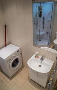 La salle de bains est pourvue d'un lave-linge et d'un lavabo. dans l'établissement Kaubi Guest Apartment, à Kuressaare