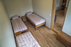 Cette petite chambre comprend 2 lits et un miroir. dans l'établissement Kaubi Guest Apartment, à Kuressaare