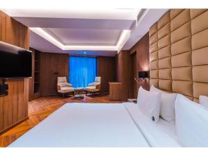 una camera con letto e TV a schermo piatto di Grand Dhillon Hotel a Bhilai