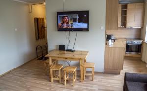 a living room with a table and a television on the wall at Kaubi Guest Apartment in Kuressaare