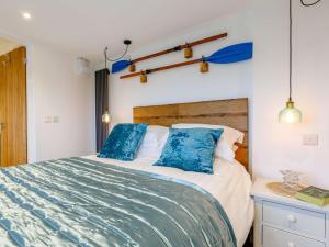 a bedroom with a large bed with blue pillows at 1 Bed in Braunton 86987 in Braunton