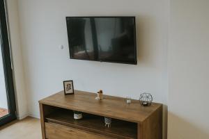 einen Flachbild-TV an einer Wand mit einem Holztisch in der Unterkunft Apartment My Choice in Sarajevo
