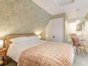 1 dormitorio con 1 cama, 1 mesa y 1 silla en 1 bed in Little Walsingham 87077, en Little Walsingham