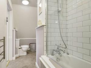 a white bathroom with a tub and a toilet at 1 bed in Little Walsingham 87077 in Little Walsingham