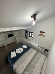 a small bedroom with a bed and a window at Pousada La Sierra in Campos do Jordão