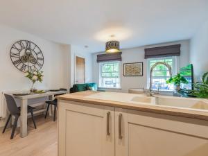 a kitchen and dining room with a sink and a table at 1 Bed in Brockenhurst 87525 in Brockenhurst