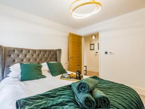 a bedroom with a large bed with green pillows at 1 Bed in Brockenhurst 87525 in Brockenhurst