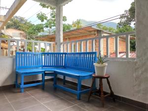 a blue bench on a balcony with a plant at Central Habitación en Minca in Minca