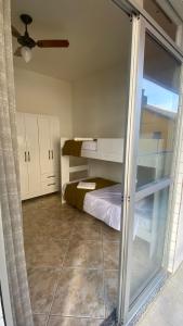 - une petite chambre avec des lits superposés et une fenêtre dans l'établissement Apartamento encantador a uma quadra do melhor trecho da Praia do forte- Cabo Frio, à Cabo Frio