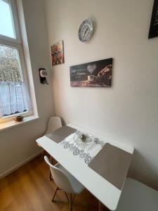 a white table and chairs in a room with a window at Gästewohnung Elegance in Halle an der Saale