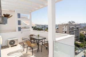an apartment with a balcony with a table and chairs at Elegant apartment with breathtaking cityscape view (Drap_F5) in Piraeus