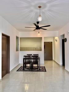 a dining room with a table and a ceiling fan at Omak Kito Homestay Melaka in Kampong Alor Gajah
