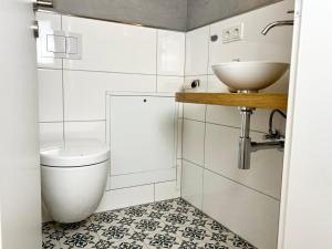 ein Bad mit einem Waschbecken und einem WC in der Unterkunft Historisches Kontorhaus, Zentral, 2Zi., Netflix! in Emden