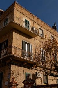 Un edificio de ladrillo con balcones a los lados. en Cappelluti 1924, en Matera