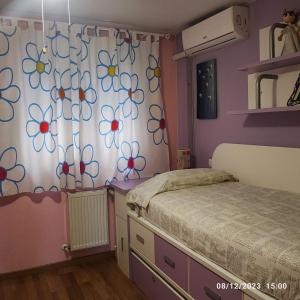 um quarto com uma cama e uma cortina com flores em Habitación individual con baño privado en casa particular em Madri