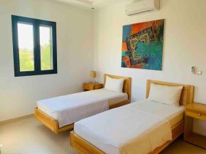 1 dormitorio con 2 camas y ventana en Villa climatisée avec piscine sans vis-à-vis, en Essaouira
