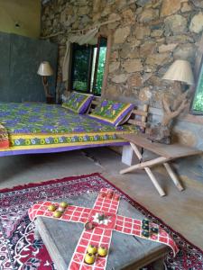 a room with two beds and a stone wall at Anokho in Nīmāj