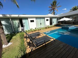 a villa with a swimming pool and a house at Cantinho do sossego in Porto Seguro