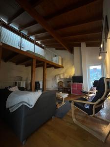 a living room with a bed and two chairs in it at Turm Hämelmaous in Echternach