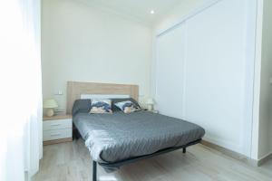 1 dormitorio con 1 cama y suelo de madera en La Deseada, en Murcia