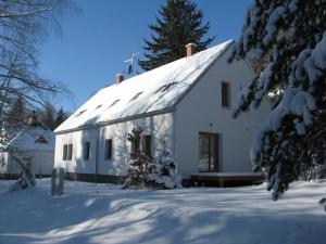 een wit huis met sneeuw op de grond bij Penzion Blanko in Nová Bystřice