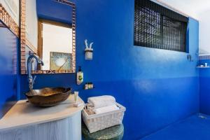 un bagno blu con un lavandino e uno specchio di The Singing Tree a Goa Velha