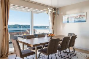 a dining room with a table and chairs and a large window at Luxury Apartment Tisa in Brodarica