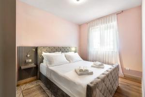 a bedroom with a bed with two towels on it at Luxury Apartment Tisa in Brodarica