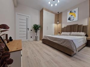 a bedroom with a large bed and a wooden floor at KSY Hotel Family Stay in Tbilisi City