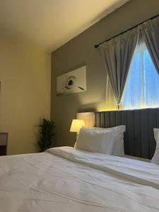 a bedroom with a large white bed with a window at شقق ثمانين بارك1 in Khamis Mushayt