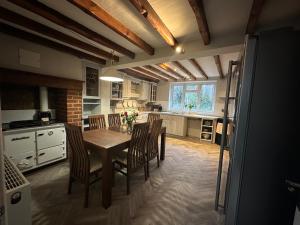 a kitchen with a wooden table and chairs in it at 2 x King & 1 Single bedroom - Sleeps 5 - Kitchen - by Canal in Barton under Needwood