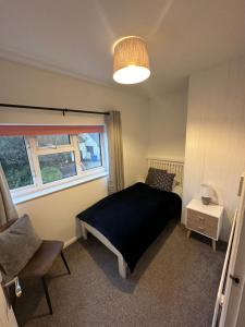 a bedroom with a bed and a chair and a window at 2 x King & 1 Single bedroom - Sleeps 5 - Kitchen - by Canal in Barton under Needwood