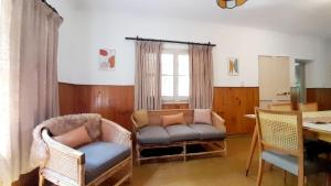 ein Wohnzimmer mit einem Sofa, Stühlen und einem Tisch in der Unterkunft Casa Gloria y Vicente in Potrerillos