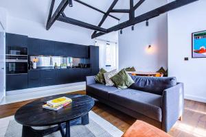 uma sala de estar com um sofá e uma mesa em Popular 1BR Apartment Close to Queens Park TUBE with SUPER FAST INTERNET em Londres