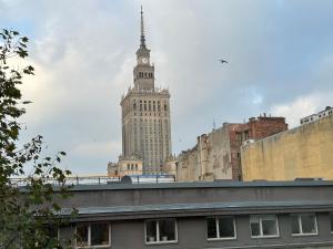 a tall building with a clock tower in a city at Cosy Dream City Center Apartment by Renters in Warsaw