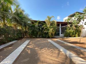 a road in front of a house with palm trees at Casa María Bonita in Pérula