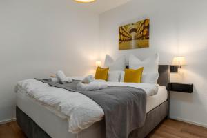 a bedroom with a large bed with yellow and white pillows at Vivamosel: Appartement mit Mosel & Burgblick - Balkon - Parken - Aufzug - Fahrradraum in Cochem +21 photos