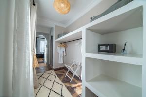 Zimmer mit weißen Regalen und einer Mikrowelle in der Unterkunft Villa Chems - Al Ouidane in Marrakesch