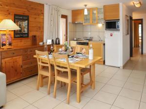 una cucina con tavolo in legno e frigorifero bianco di Apartment Quille du diable 19 by Interhome a Nendaz