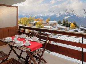 a table on a balcony with a view of the mountains at Apartment Quille du diable 19 by Interhome in Nendaz
