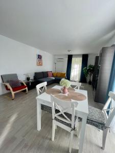 sala de estar con mesa blanca y sillas en Fly Airport Residences & Therme-SELF CHECK-IN en Otopeni