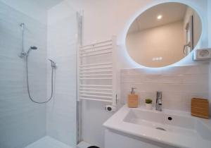 uma casa de banho branca com um lavatório e um espelho em Maison au cœur de l’Estaque em Marselha