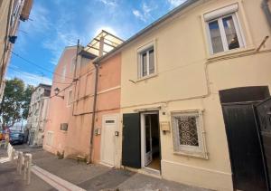 a building on a street with a gate and a door at Maison au cœur de l’Estaque in Marseille