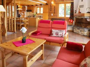 a living room with red chairs and a table at Chalet Gamine by Interhome in Veysonnaz