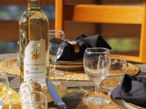 ヴェゾナにあるChalet Gamine by Interhomeのグラス付きテーブルに座るワイン1本