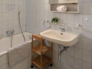 a bathroom with a sink and a shower and a tub at Chalet Gamine by Interhome in Veysonnaz