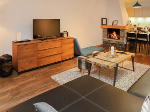 ein Wohnzimmer mit einem TV und einem Kamin in der Unterkunft Apartment Chaedoz 24-1 by Interhome in Nendaz