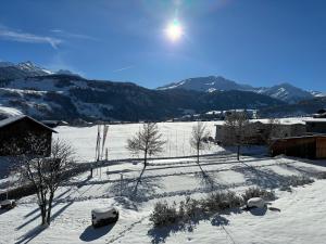 a snow covered field with mountains in the background at Apartment Apt B 033 by Interhome in Disentis