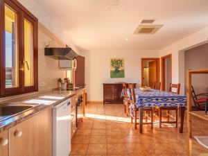 een keuken en eetkamer met een tafel en stoelen bij Apartment Finca Can Corritx - MUO126 by Interhome in Muro
