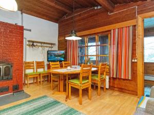 uma sala de jantar com uma mesa e cadeiras e uma lareira em Holiday Home Rajamaja by Interhome em Palikainen